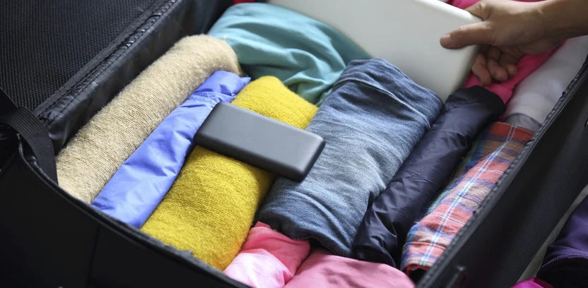 Vêtements roulés rangés dans une valise ouverte